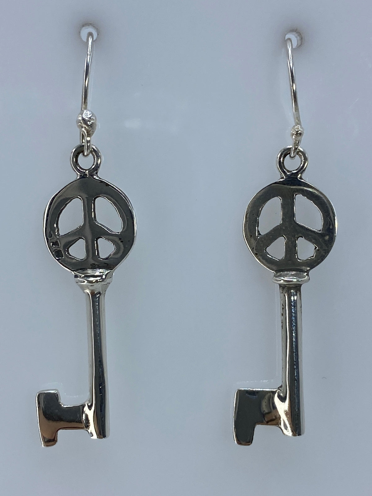 Par de aretes de plata con símbolo de paz calado, colgando en gancho de plata 925
