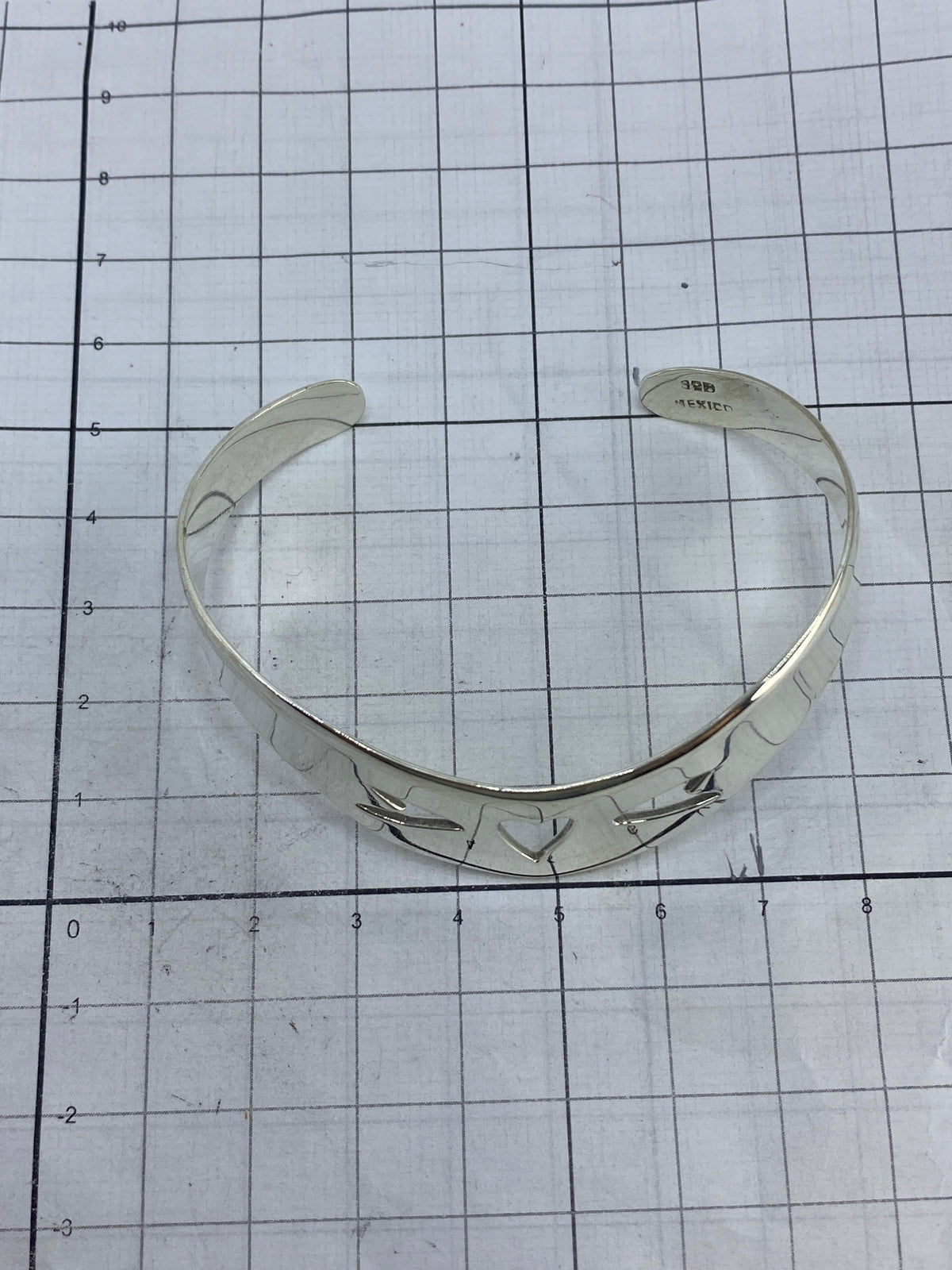 Brazalete de plata puesto en la muñeca, demostrando cómo se ajusta como esclava rígida
