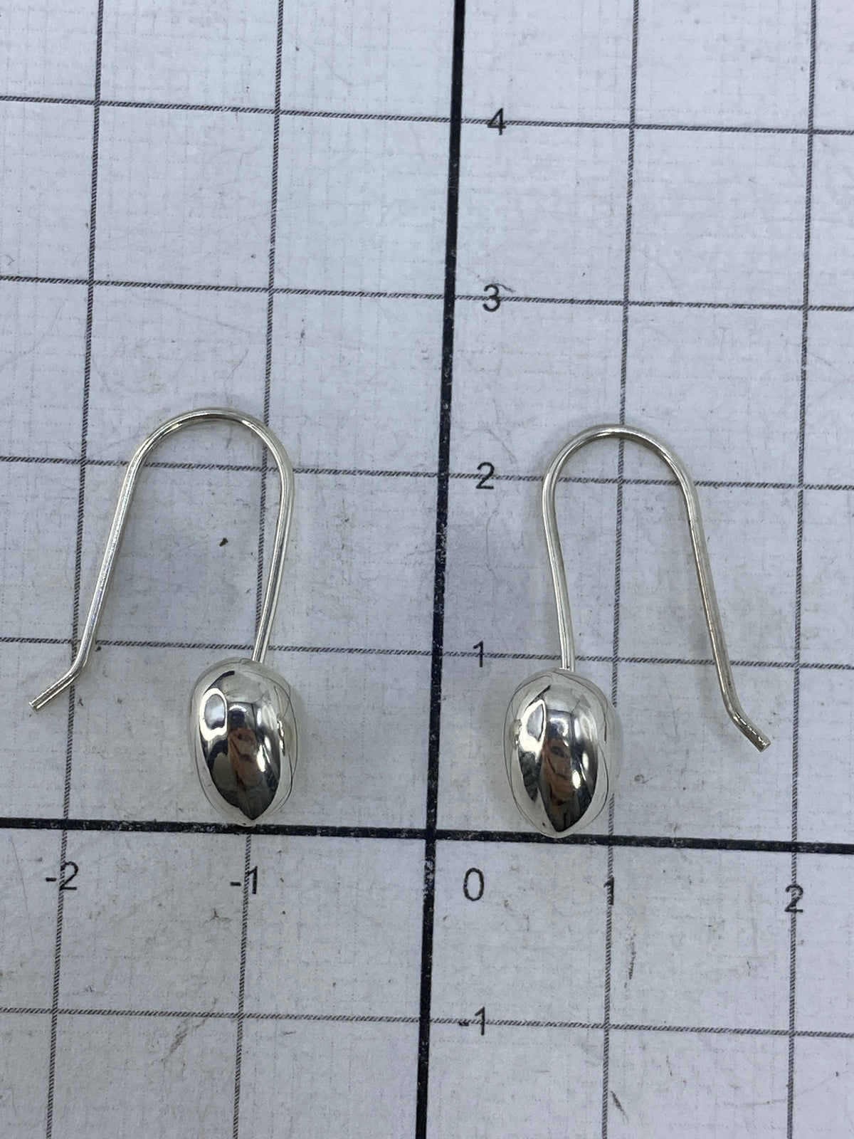 Pesaje de los aretes en escala de precisión, indicando 1.33 gramos el par