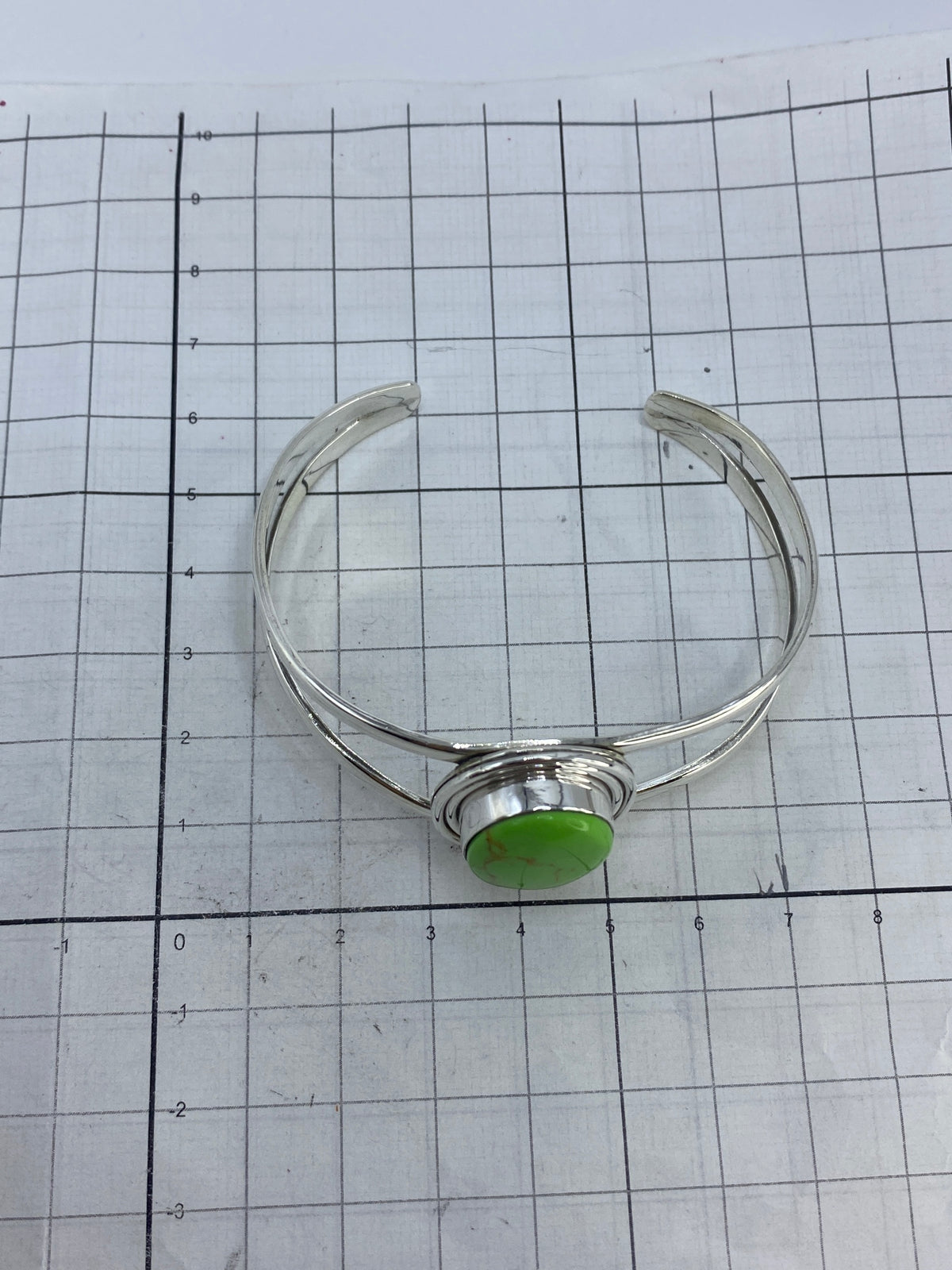 Brazalete sobre fondo blanco mostrando el Quinto 950 en la plata