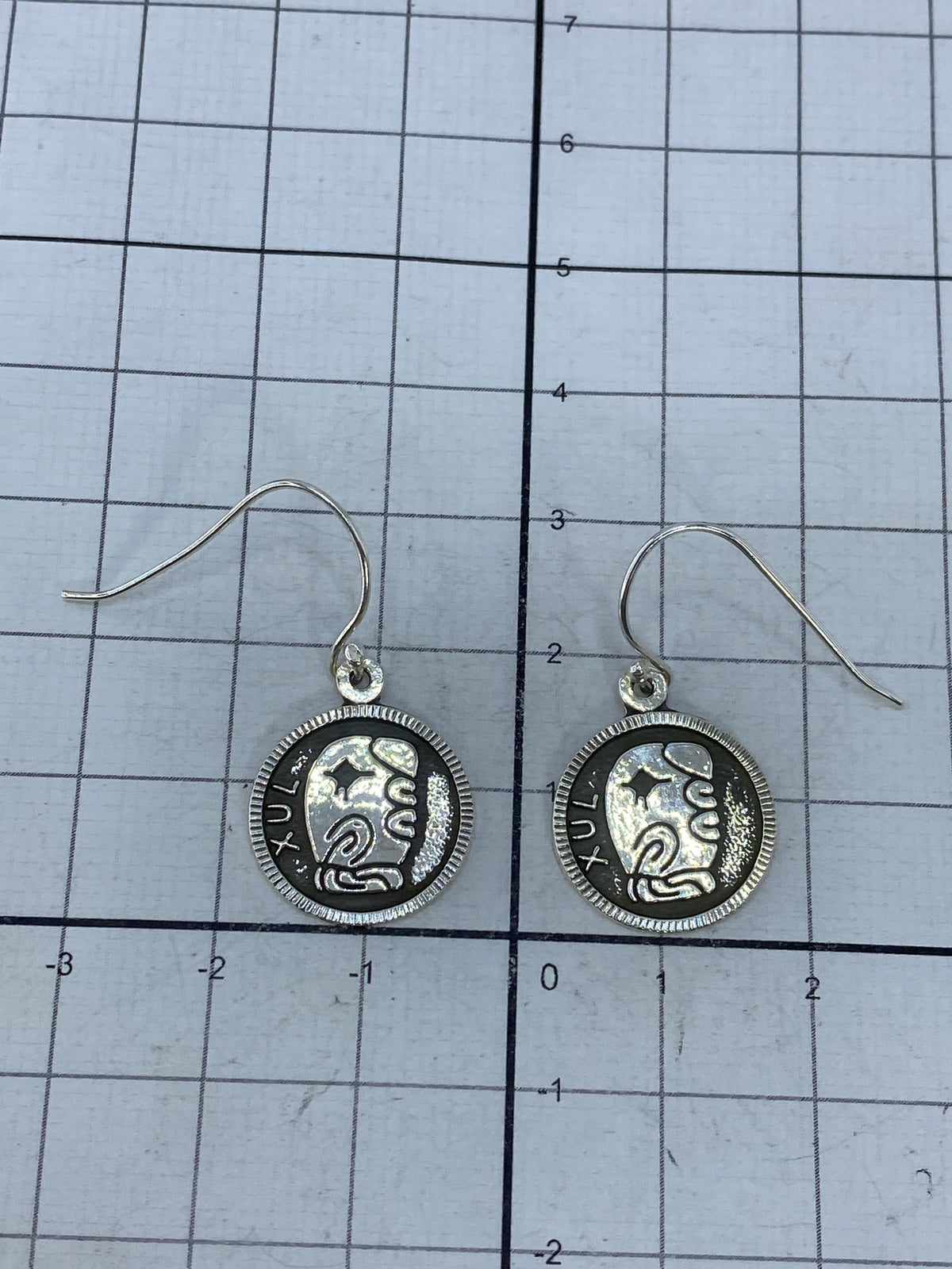 Respaldo de los aretes mostrando el acabado pulido de la plata 925 con marca del Quinto