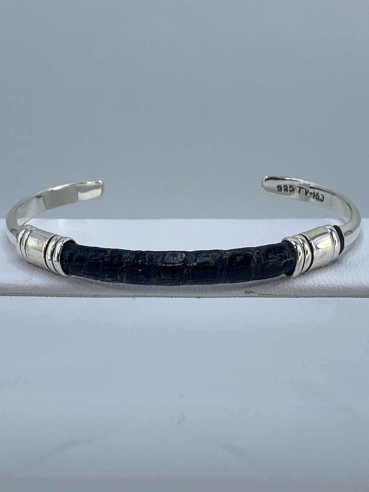Brazalete de plata cartoneado abierto con textura tipo piel de víbora, visto de frente