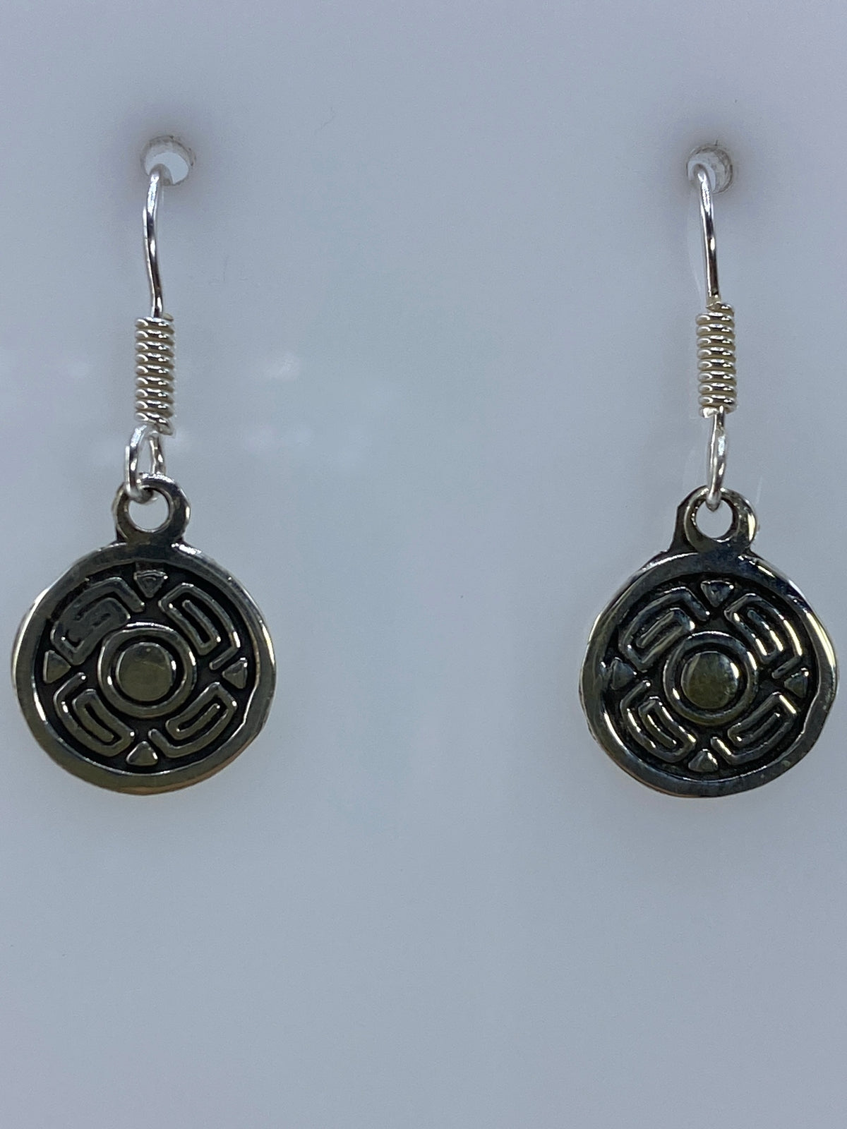 Par de aretes de plata repujados con diseño geométrico circular en tono plateado brillante