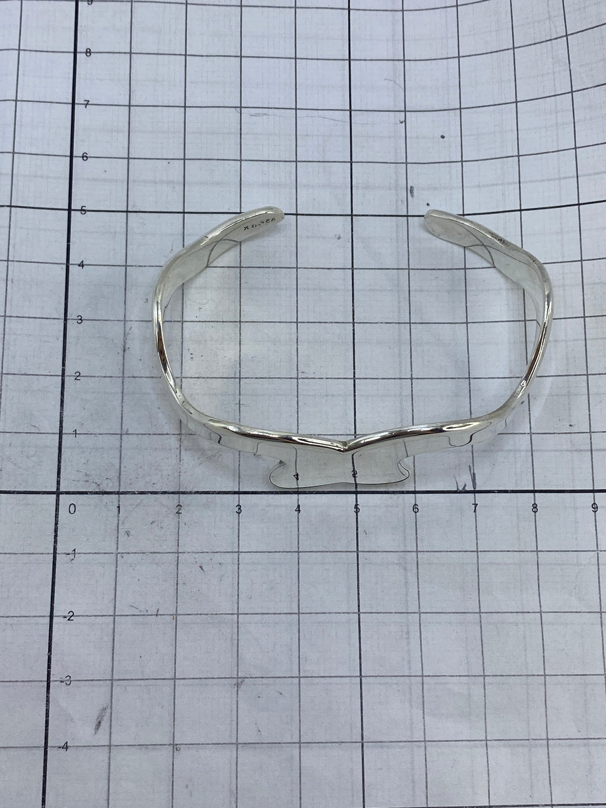 Brazalete de plata sobre fondo blanco mostrando el Quinto 925