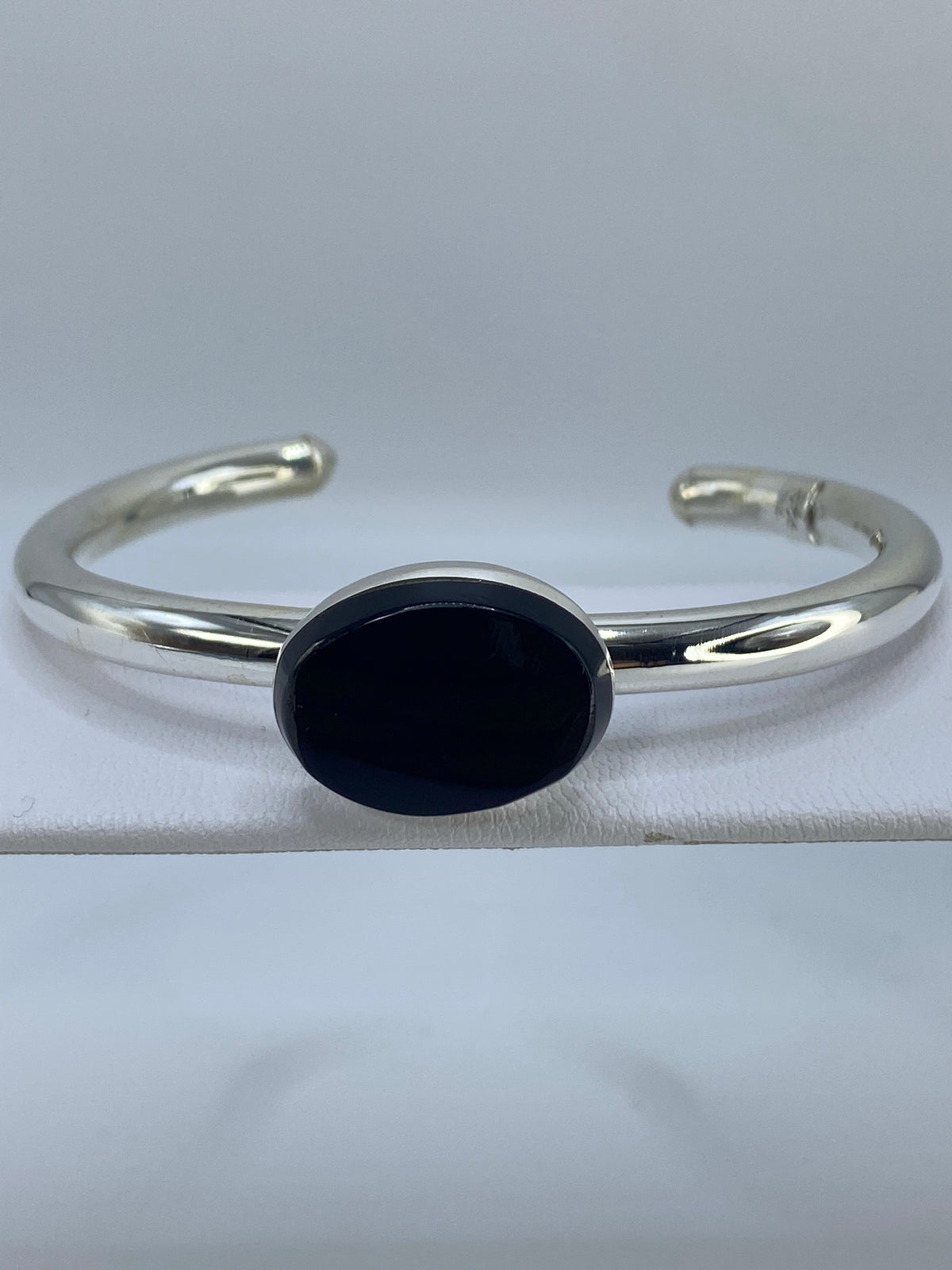 Brazalete de plata puesto en la muñeca mostrando el ónix negro brillante
