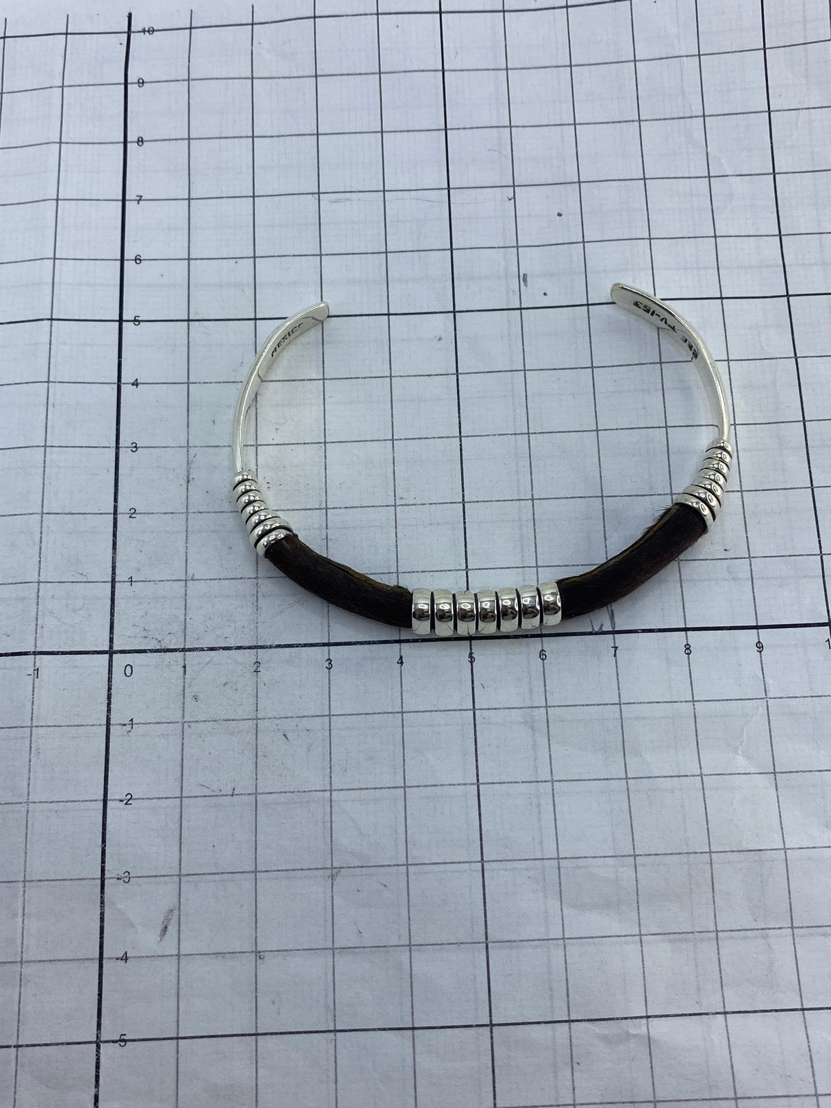 Brazalete sobre fondo blanco con escala de centímetros para referencia