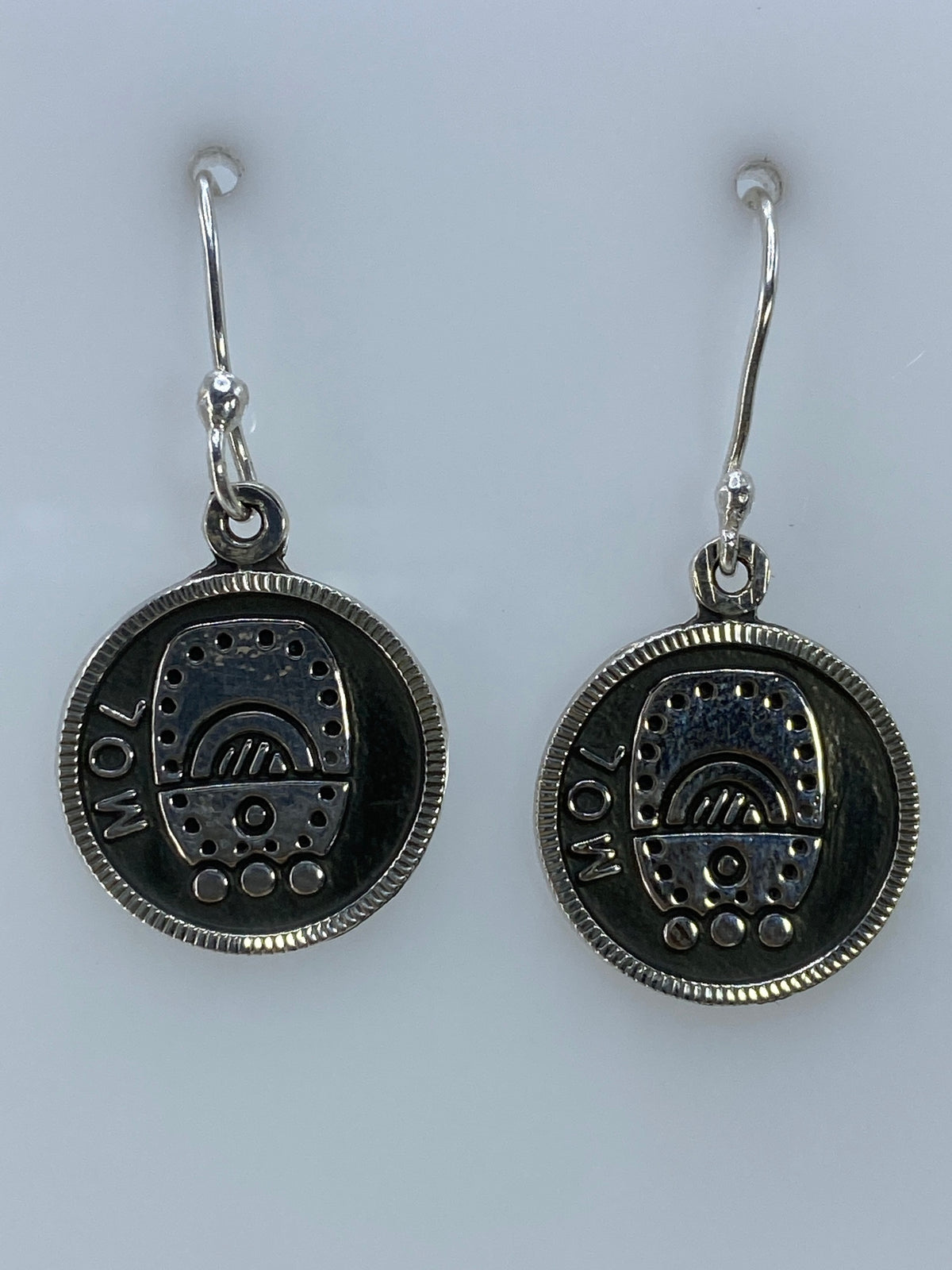 Par de aretes de plata con motivo circular repujado, prehispánico, colgando de ganchos de plata