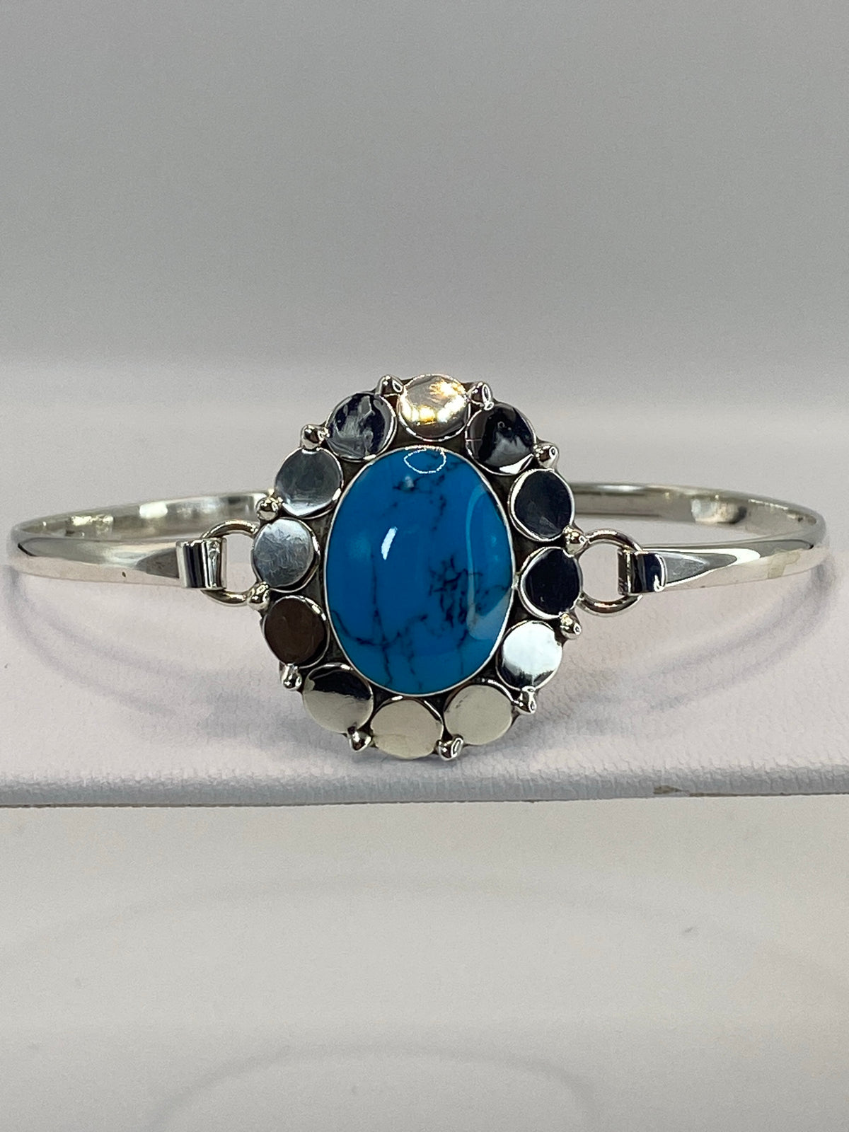 Brazalete rígido de plata con turquesa azul en la muñeca de una mujer