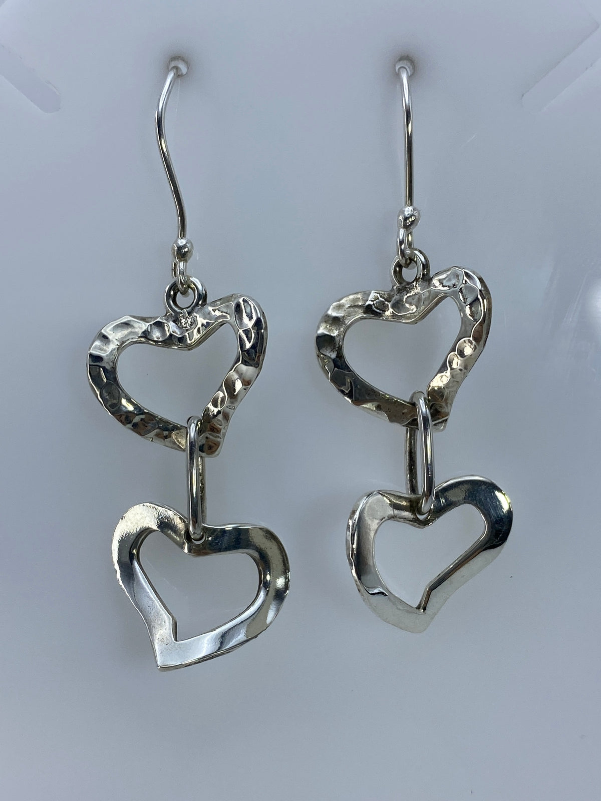 Detalle lateral de los aretes de corazones — acabado pulido y brillante