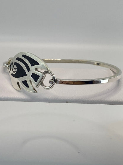 Brazalete cerrado mostrando el engaste de ónix negro y la banda ancha de plata