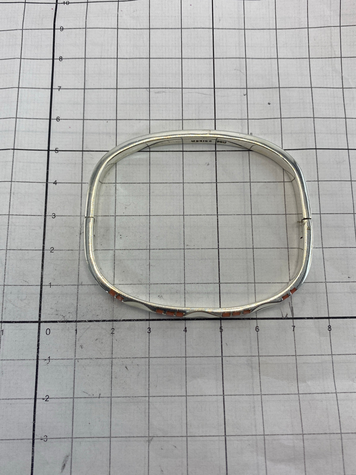 Brazalete sobre escala de medición mostrando diámetro interior de 6.4 cm y ancho de 5.2 cm