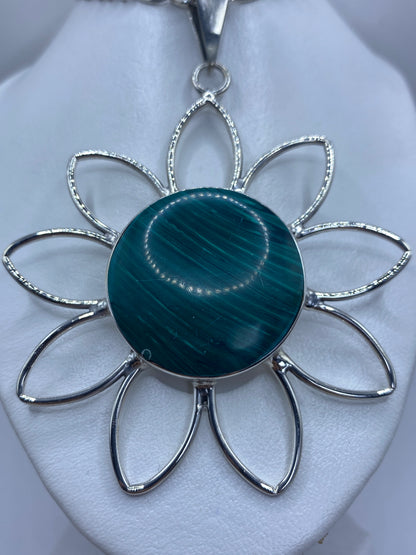 Dije flor de plata 950 con malaquita verde engastada en el centro, ocho pétalos calados