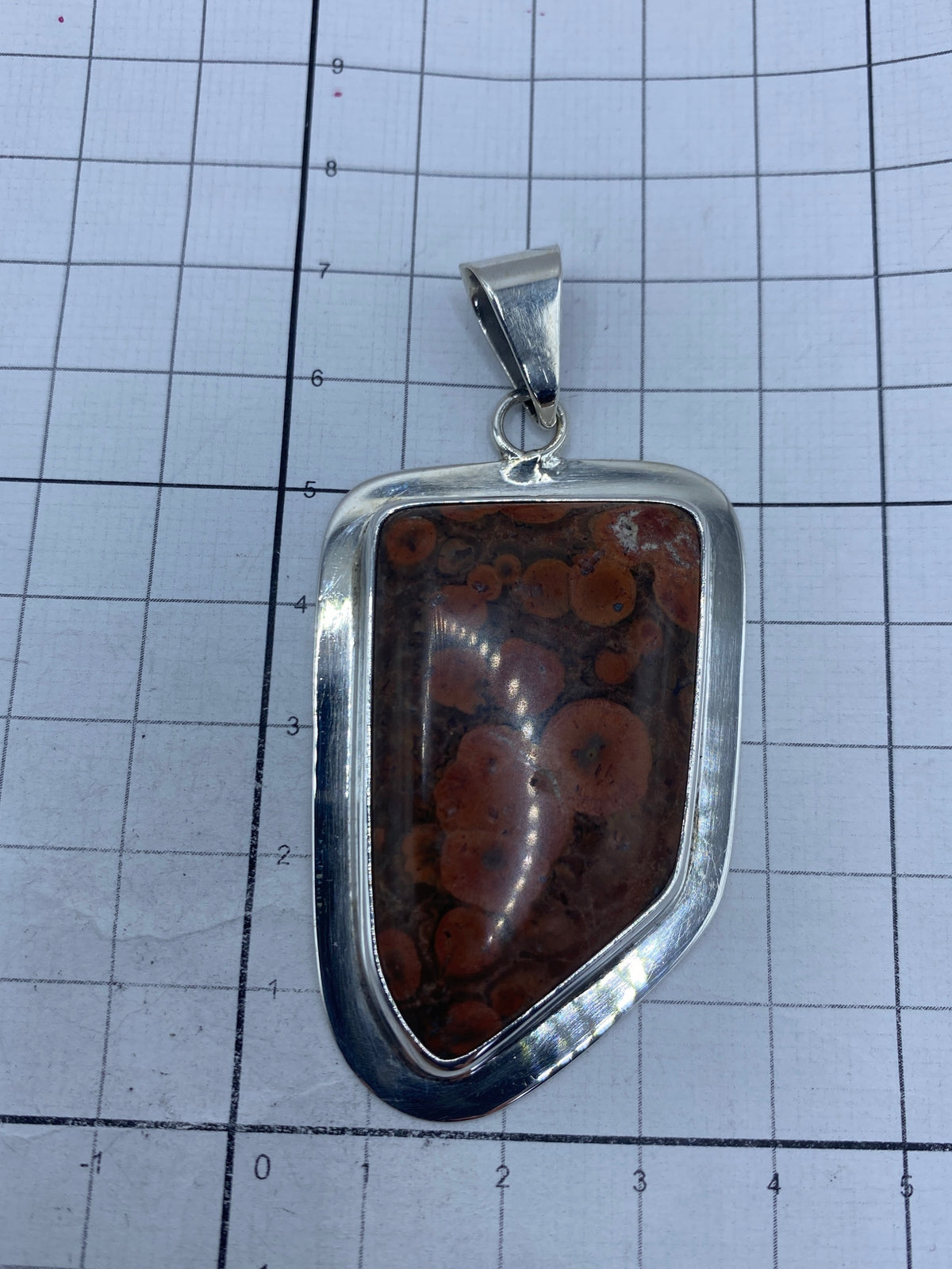 Dije de Taxco sobre fondo blanco mostrando las medidas 7.2 × 3.2 cm