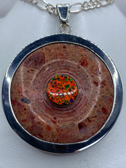 Dije circular de plata 950 con ópalo de fuego multicolor en el centro, colgando de una cadena de plata