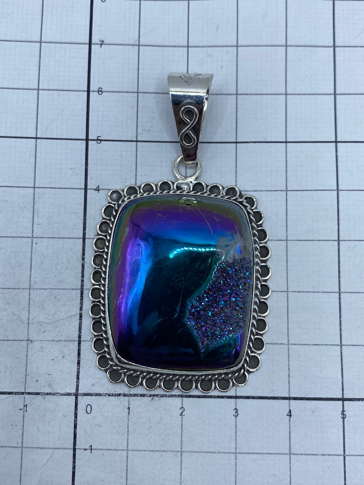Piedra morada pulida con brillo hipnotizante, enmarcada en argollas de plata