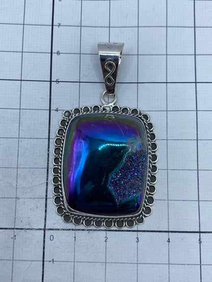 Piedra morada pulida con brillo hipnotizante, enmarcada en argollas de plata