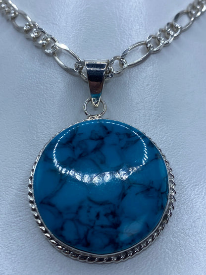 Detalle del engaste de turquesa en plata 950, visto de frente mostrando el color azul profundo