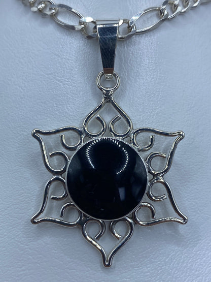 Dije mandala de plata 950 con ónix negro engastado a mano, moldura calada con doce pétalos
