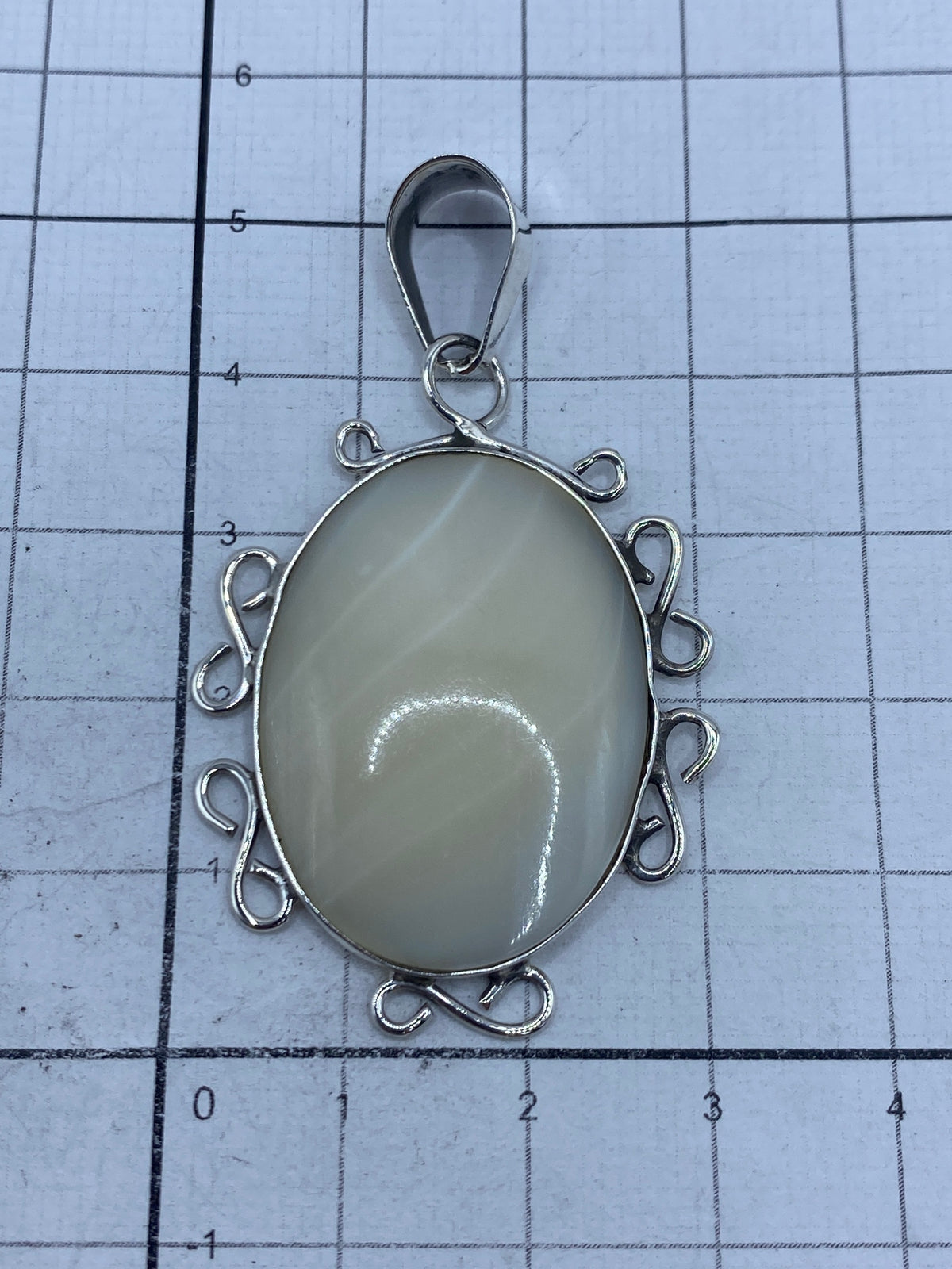 Dije pesado en báscula de joyería, marca 5.9 gramos, con sello de autenticidad 950 visible