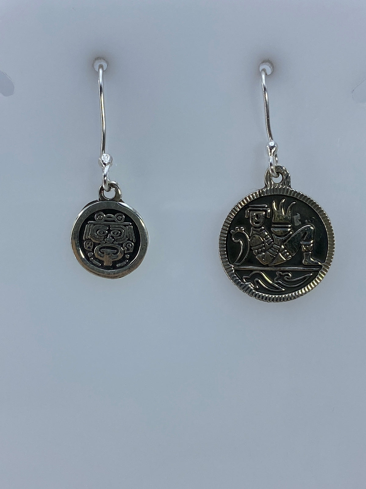 Arete izquierdo de plata con rostro azteca en relieve, vista frontal
