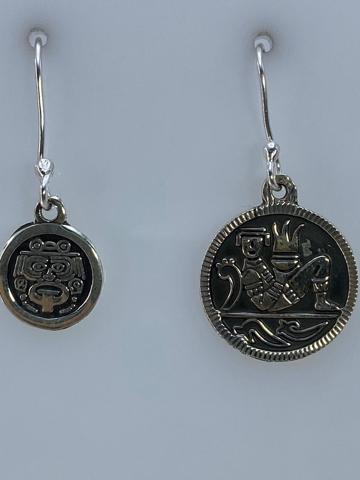 Arete derecho de plata con glifo prehispánico, detalle del repujado
