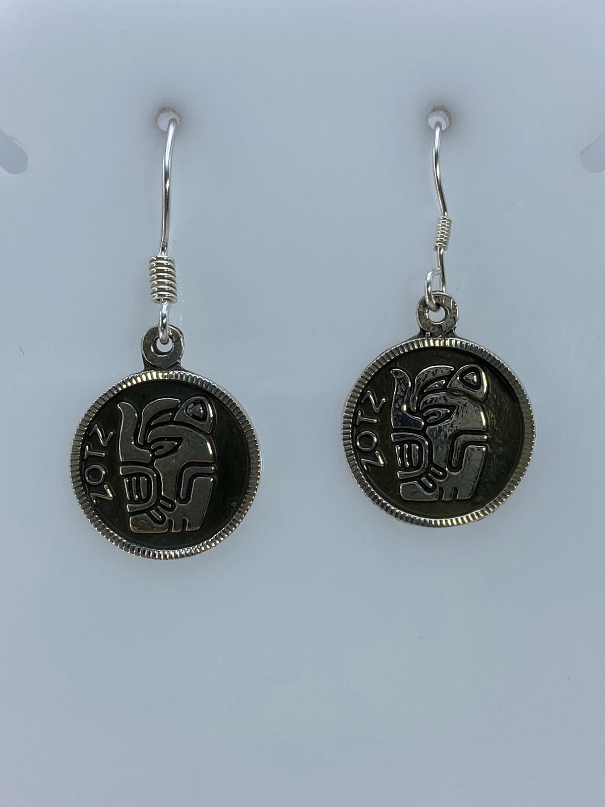 Detalle del relieve prehispánico grabado en aretes de plata 950
