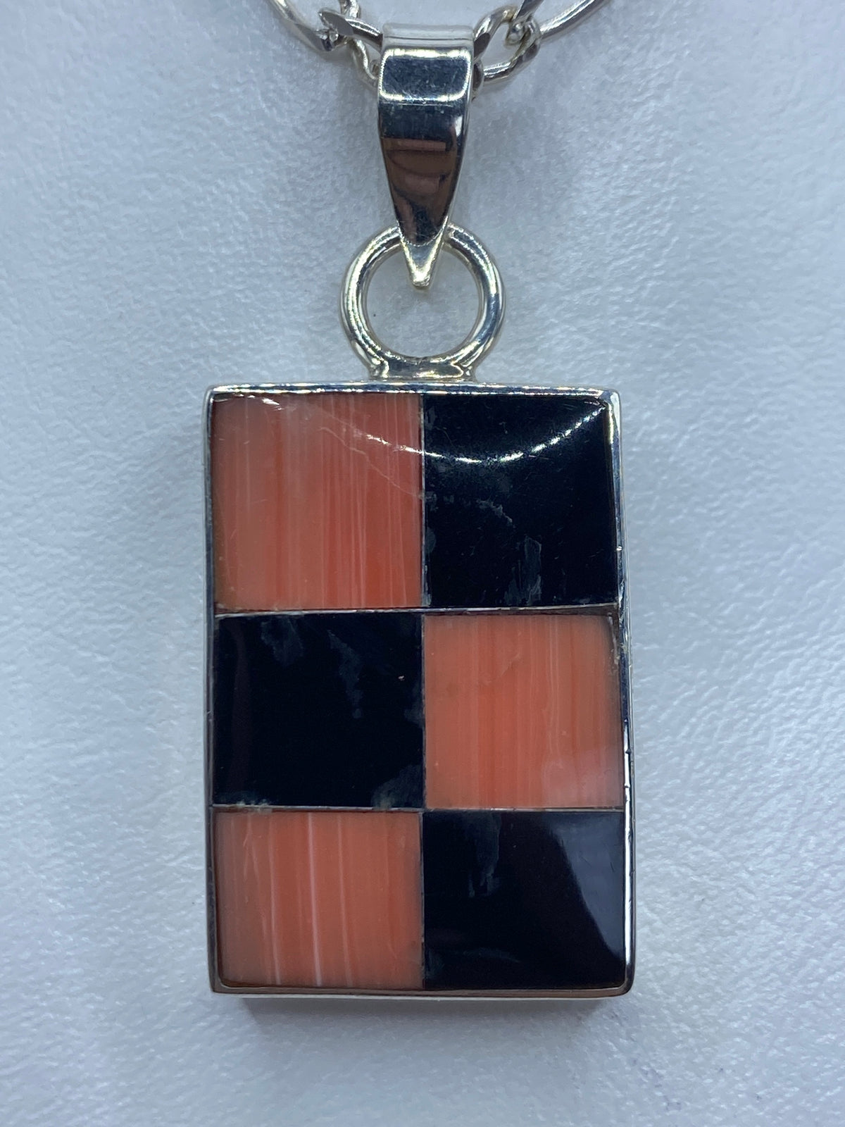 Dije de plata 950 con coral naranja y ónix negro en patrón geométrico de seis cuadros alternados