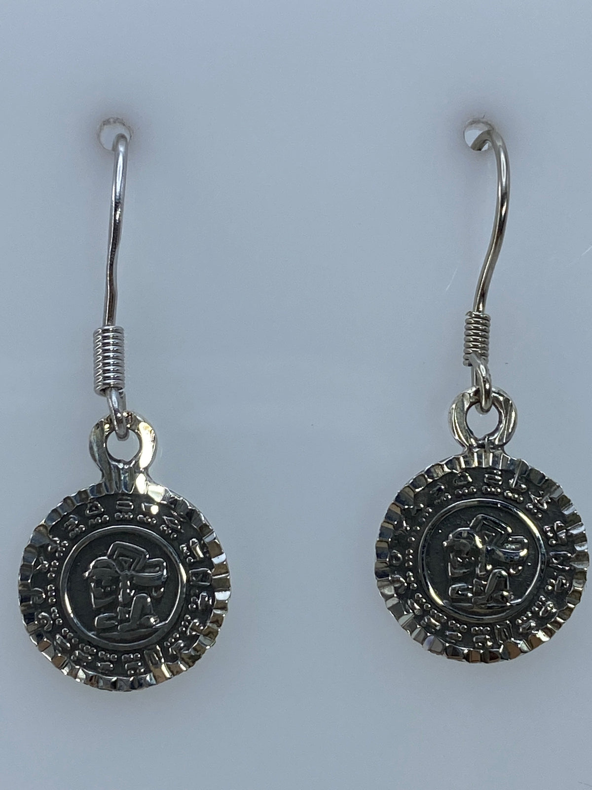 Aretes Calendario Azteca sobre medidor en milímetros, mostrando tamaño de 3.1 cm