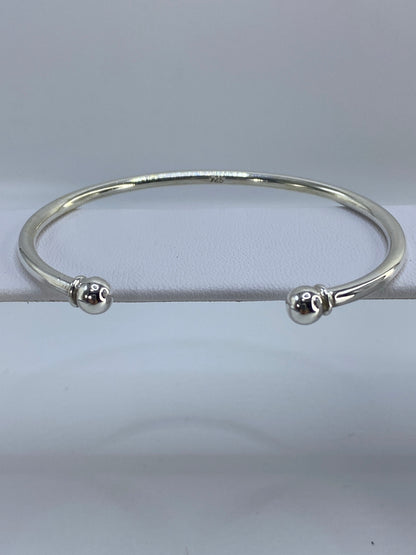 Brazalete de plata cartoneado en la muñeca, mostrando el volumen 3D de la técnica