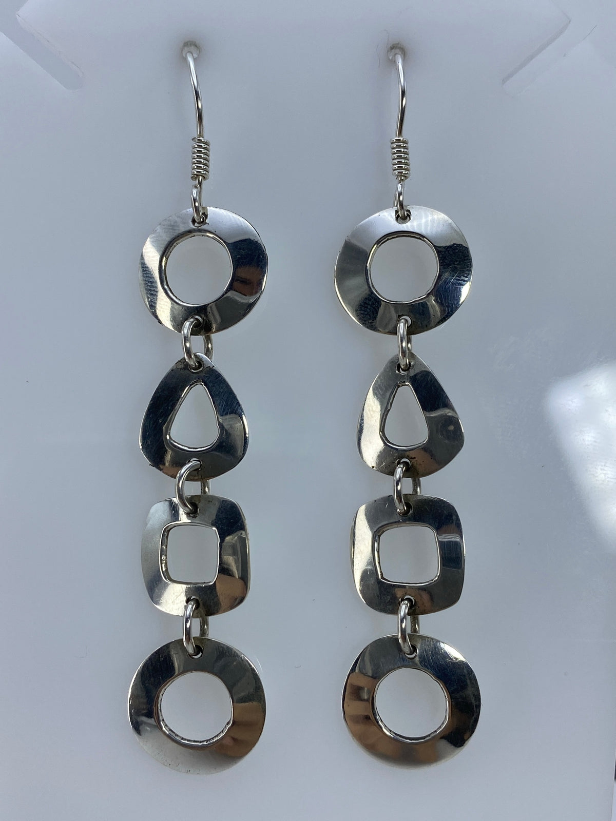 Vista frontal de los aretes colgantes con detalle del corte preciso de cada forma