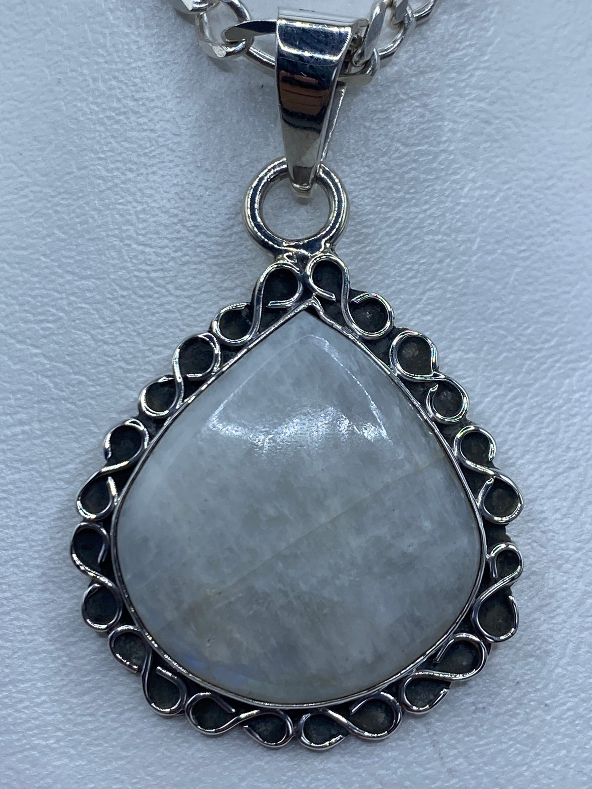 Dije de plata con cuarzo cristalino iridiscente, engastado a mano en marco ornamental