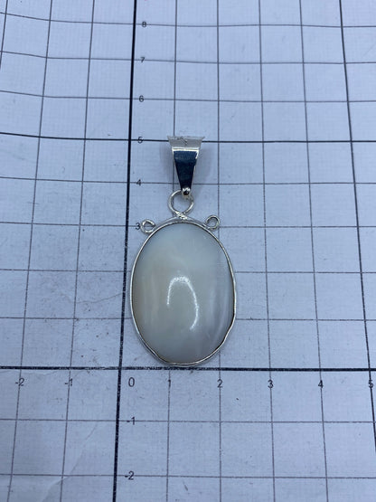 Dije de plata con perla en escala de peso sobre balanza, mostrando 5.8 gramos