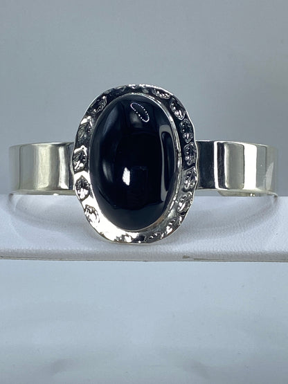 Brazalete puesto en la muñeca, detalle del onix negro y la plata brillante