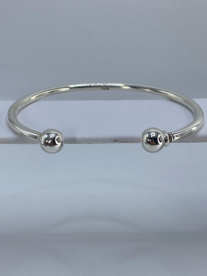 Brazalete de plata cartoneado puesto en la muñeca, mostrando el volumen 3D y el diámetro interior