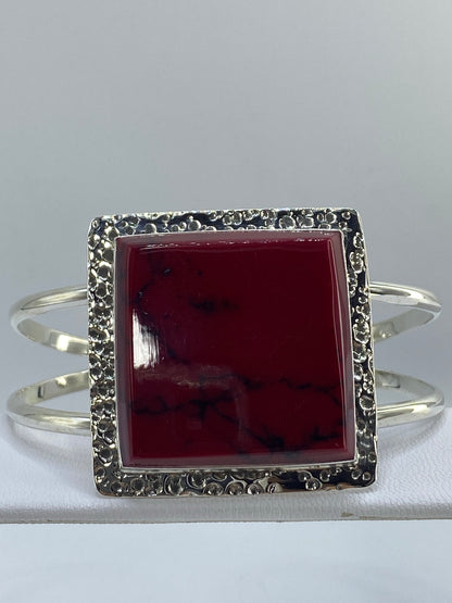 Detalle del engaste de coral rojo a mano en la plata pulida