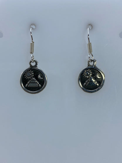 Detalle del repujado en cada arete mostrando la pirámide, sol y luna
