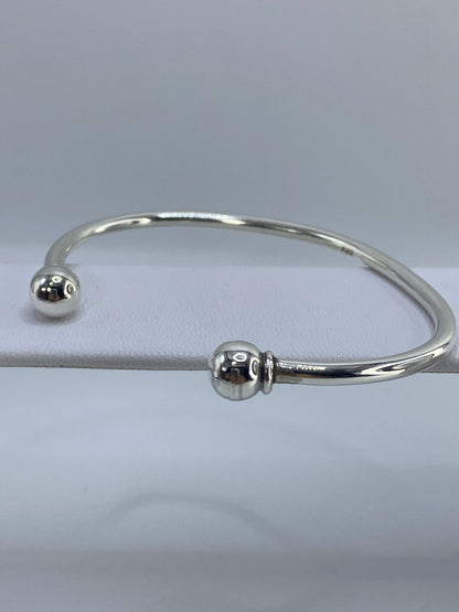 Brazalete cartoneado en la muñeca, mostrando el cierre suave y la anchura de la banda
