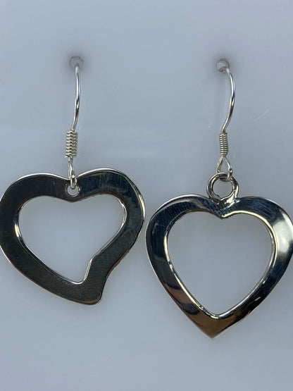 Aretes de plata corazón vistos desde el frente, mostrando la precisión del calado