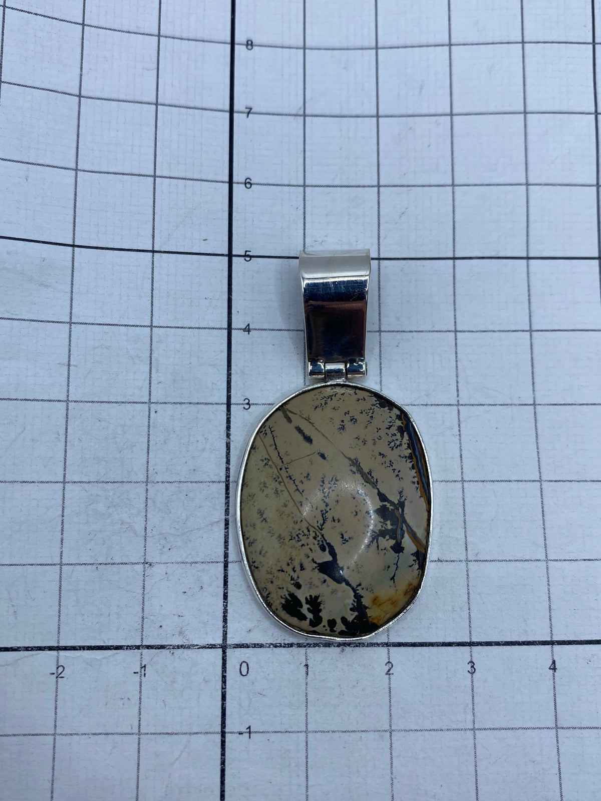 Dije colgando en cadena de plata, sobre pecho