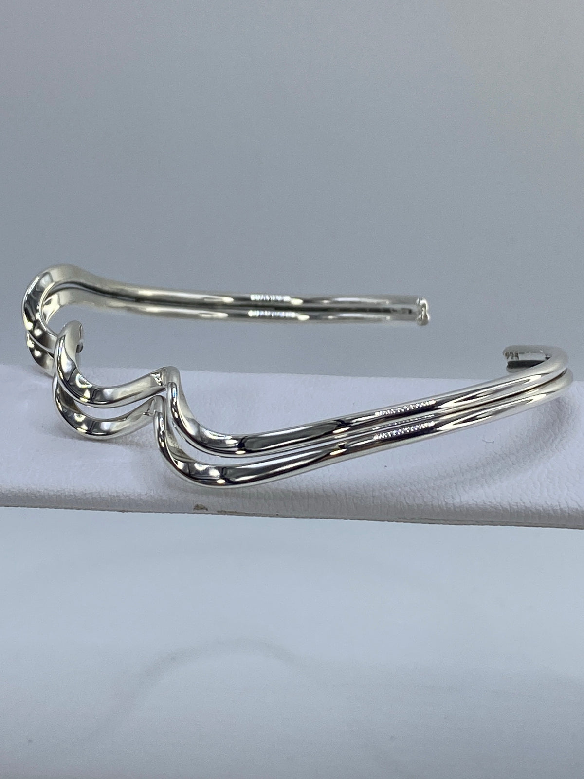 Brazalete de plata cartoneado mostrando el volumen tridimensional característico