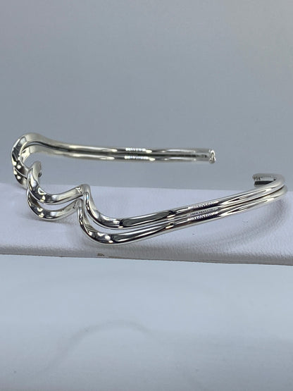 Brazalete de plata cartoneado mostrando el volumen tridimensional característico