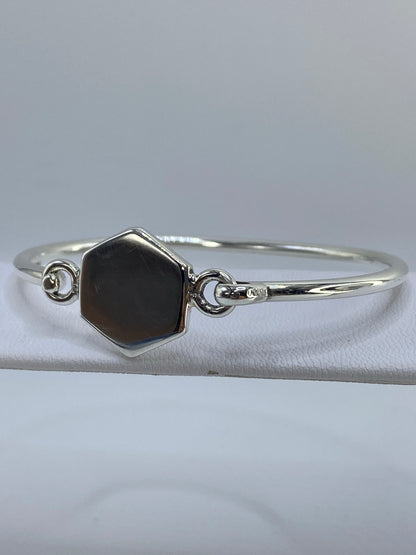 Brazalete abierto de lado, detalle del cartoneado y los volúmenes facetados