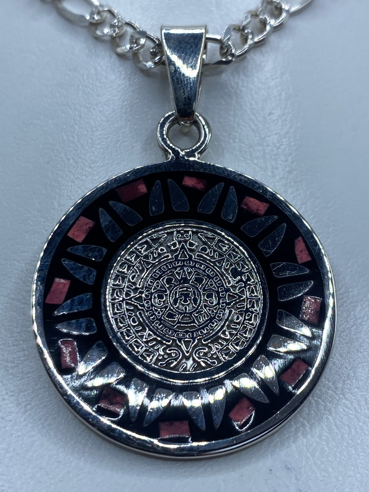 Dije Calendario Azteca de plata 925 con piedra rosa incrustada, símbolo prehispánico de Taxco