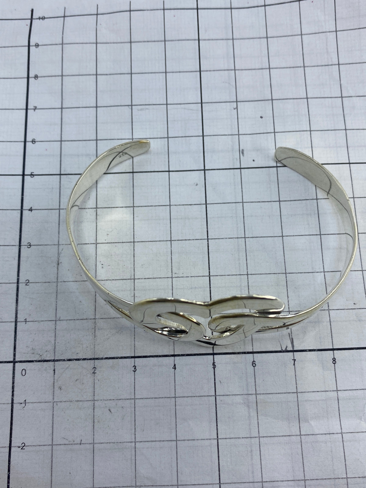 Brazalete en plata 925 sobre fondo blanco mostrando el Quinto y el pulido espejo