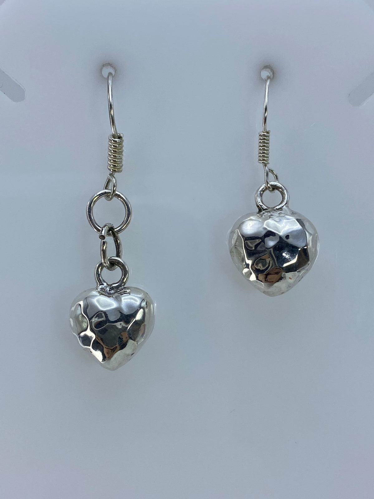 Aretes de corazón en plata 925 vistos desde el frente, brillo pulido evidente