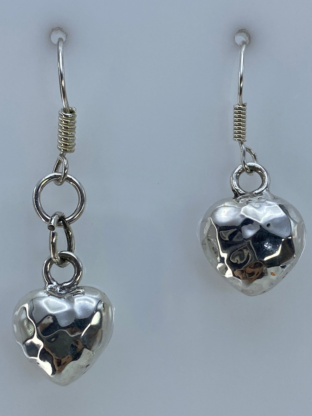 Detalle de escala: aretes de corazón de 3.8 cm junto a regla de centímetros
