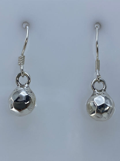 Par de aretes de plata con diseño geométrico facetado, brillante, sobre fondo blanco