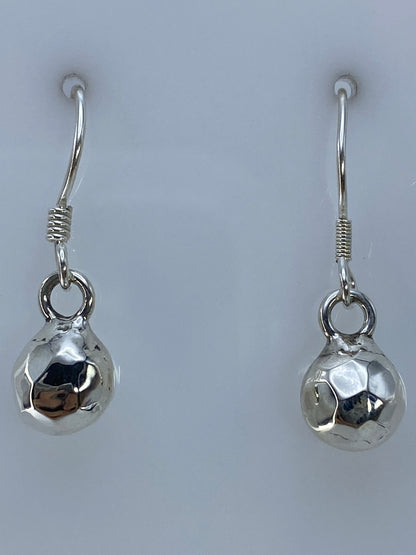 Detalle lateral del cartoneado: volumen 3D de la esfera facetada en plata