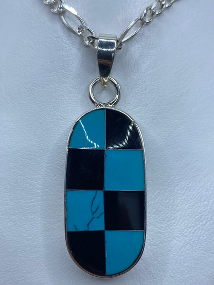Dije de plata con cuadrícula geométrica de turquesa azul y ónix negro engastadas a mano