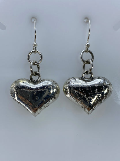 Detalle lateral de arete de corazón en plata con volumen 3D, cartoneado de Taxco